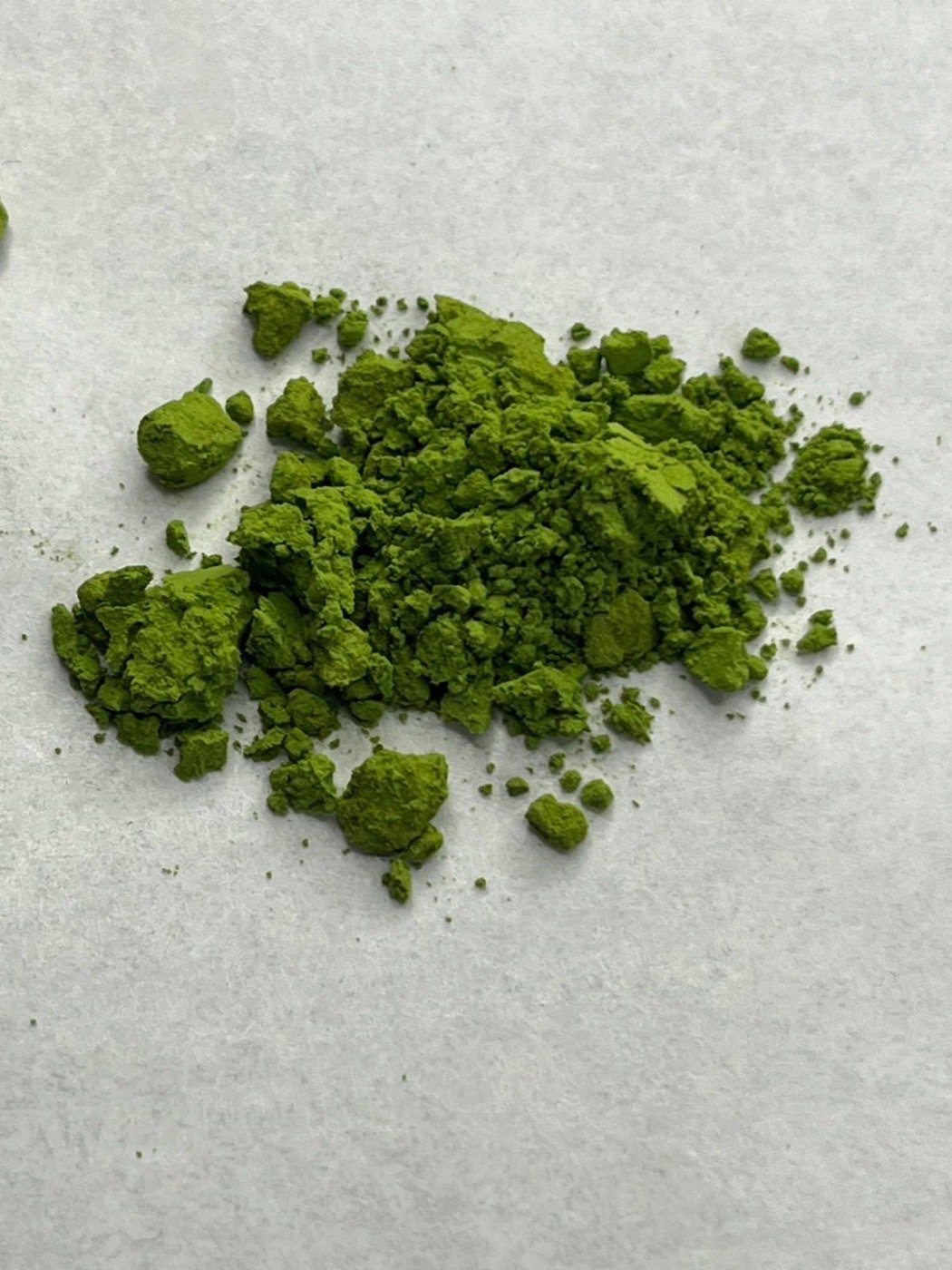 Gros plan sur de la poudre de matcha, fine et d’un vert profond.